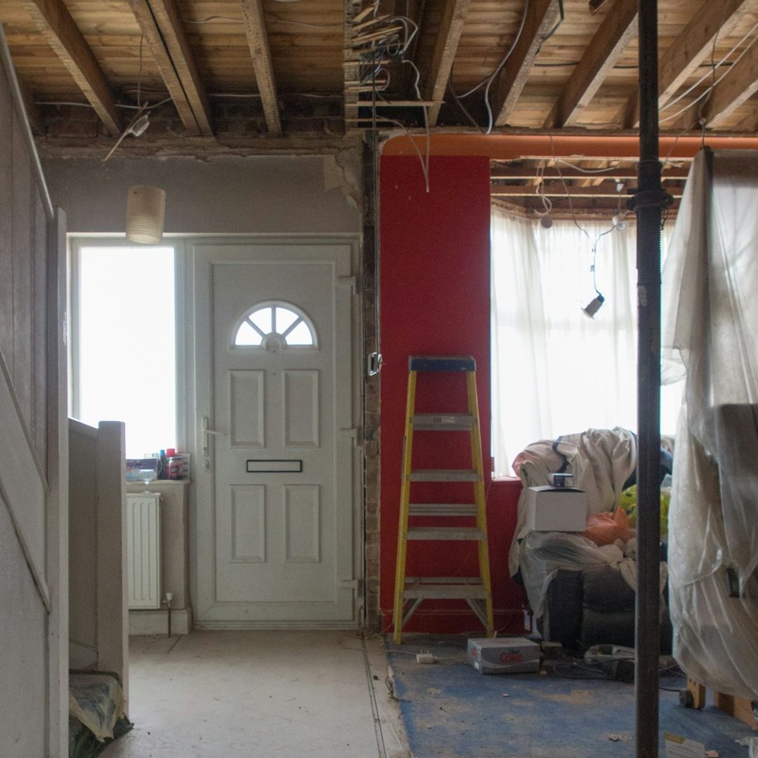 Inside Home Active Remodel Renovation scene showing an open doorway, ladder, and unfinished living space.